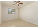 Bedroom with a ceiling fan and a window, showcasing neutral tones and tile flooring at 2908 N 54Th Dr, Phoenix, AZ 85031