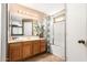 Traditional bathroom design with wood cabinets, a large vanity mirror and a shower-tub combination at 3006 W Matthew Dr, Phoenix, AZ 85027