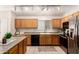 Kitchen featuring oak cabinets, tiled flooring, and modern appliances at 3006 W Matthew Dr, Phoenix, AZ 85027