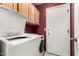 Laundry room with a front loading washer and dryer, wood cabinets, and a door to the exterior at 3006 W Matthew Dr, Phoenix, AZ 85027