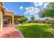 Green backyard featuring a covered patio with patio furniture, a grill and manicured landscaping at 3025 N Desert Horizons Ln, Casa Grande, AZ 85122