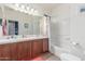 Bathroom with double sinks, cherry cabinet vanity, and tub and shower combo at 3025 N Desert Horizons Ln, Casa Grande, AZ 85122
