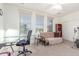 Bright bedroom featuring carpet, a ceiling fan, a futon, and a desk with a rolling chair at 3025 N Desert Horizons Ln, Casa Grande, AZ 85122
