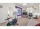 Carpeted bedroom with a large quilt, fitness equipment, TV, and a view into an adjoining space at 3025 N Desert Horizons Ln, Casa Grande, AZ 85122