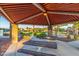 A community picnic area featuring covered seating with metal tables and red rock landscape for outdoor enjoyment at 3025 N Desert Horizons Ln, Casa Grande, AZ 85122