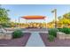 Community playground with various play structures, covered area, benches, and well-maintained landscaping at 3025 N Desert Horizons Ln, Casa Grande, AZ 85122