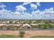 Backyard featuring artificial turf, concrete patio with dining set, and desert landscaping; neighborhood in the distance at 3586 S Moccasin Trl, Gilbert, AZ 85297