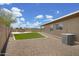 Backyard featuring artificial grass, gravel landscaping, and an AC unit at 3586 S Moccasin Trl, Gilbert, AZ 85297