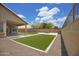 Landscaped backyard with artificial turf, patio, and block wall at 3586 S Moccasin Trl, Gilbert, AZ 85297