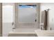 Bathroom featuring a soaking tub and a window, with white marble tiling at 3586 S Moccasin Trl, Gilbert, AZ 85297