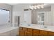 Bathroom with dual sinks, a large mirror, a soaking tub, and a view of the shower at 3586 S Moccasin Trl, Gilbert, AZ 85297