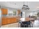 Open kitchen with stainless steel appliances, wooden cabinets, island seating, tile floors, and adjacent living area at 3586 S Moccasin Trl, Gilbert, AZ 85297