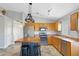 Well-lit kitchen featuring stainless steel appliances, wooden cabinetry, tile flooring and an island with seating at 3586 S Moccasin Trl, Gilbert, AZ 85297