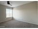 This bedroom features neutral walls, carpet, a ceiling fan, and a window for natural light at 3840 N 43Rd Ave # 34, Phoenix, AZ 85031