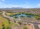 Aerial view of a neighborhood with a community lake and park with walking path at 40657 W Somers Dr, Maricopa, AZ 85138