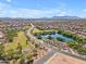 Aerial view of a neighborhood with a community lake and park with walking path at 40657 W Somers Dr, Maricopa, AZ 85138