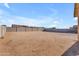 Expansive dirt backyard with block fence offers privacy and potential for customization at 40657 W Somers Dr, Maricopa, AZ 85138