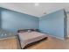 Large bedroom with carpet, a bed, and blue painted walls at 40657 W Somers Dr, Maricopa, AZ 85138