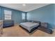 Comfortable bedroom with blue walls, and neutral carpet and décor at 40657 W Somers Dr, Maricopa, AZ 85138