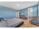 Bedroom with dresser, crib and bathroom access at 40657 W Somers Dr, Maricopa, AZ 85138