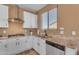 Bright kitchen featuring white cabinets, granite countertops, and stainless steel hood at 40657 W Somers Dr, Maricopa, AZ 85138