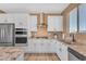 Modern kitchen with white cabinets, stainless steel appliances, and granite countertops at 40657 W Somers Dr, Maricopa, AZ 85138