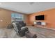 Cozy living room featuring wood-style floors, a large window, and a TV at 40657 W Somers Dr, Maricopa, AZ 85138