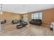 Open-concept living room with a dining table, bar seating and wood-look floors at 40657 W Somers Dr, Maricopa, AZ 85138