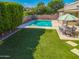 Backyard oasis features a sparkling pool with water features, lush lawn and a dining area at 4236 S John Way, Chandler, AZ 85249