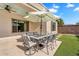 Backyard patio featuring an outdoor dining set with views of artificial turf and lush landscaping at 4236 S John Way, Chandler, AZ 85249
