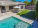 Stunning backyard showcasing a pristine pool, travertine patio, and lush artificial turf for effortless entertaining at 4236 S John Way, Chandler, AZ 85249