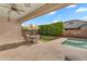 Covered patio with an outdoor dining set overlooking a manicured backyard with artificial turf and green hedges at 4236 S John Way, Chandler, AZ 85249