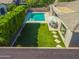 Aerial view of a backyard oasis featuring a pool, artificial turf, outdoor dining and privacy hedges at 4236 S John Way, Chandler, AZ 85249