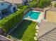 Aerial view of a backyard oasis featuring a pool, artificial turf, and manicured hedges at 4236 S John Way, Chandler, AZ 85249