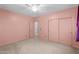 Cozy bedroom with pink walls, carpet flooring, and a closet at 4236 S John Way, Chandler, AZ 85249