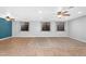 Large living room with tile flooring, ceiling fans, and multiple windows with patterned curtains at 4236 S John Way, Chandler, AZ 85249