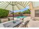Inviting pool area with fountains, patio furniture, and shade umbrella offers a relaxing oasis at 4236 S John Way, Chandler, AZ 85249