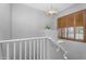 Staircase with natural light from shuttered window, white railing, and a modern light fixture at 4236 S John Way, Chandler, AZ 85249