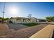 Single-story home with desert landscaping, two-car garage and covered front porch with seating area at 434 N 56Th St, Mesa, AZ 85205
