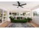 Bright living room showcasing a stylish green sofa, a modern ceiling fan, and large windows offering plenty of natural light at 434 N 56Th St, Mesa, AZ 85205