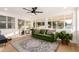 Bright living room showcasing a stylish green sofa, a modern ceiling fan, and large windows offering plenty of natural light at 434 N 56Th St, Mesa, AZ 85205
