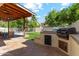 Inviting backyard with built-in grill, lush lawn, a fence leading to pool at 438 E Larkspur Ln, Tempe, AZ 85288