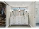Beautiful bathroom featuring double sinks with white cabinets and modern fixtures adjacent to walk-in closet at 438 E Larkspur Ln, Tempe, AZ 85288