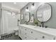 Neutral bathroom design featuring double vanity, stylish lighting fixtures, and shower-tub combination at 438 E Larkspur Ln, Tempe, AZ 85288