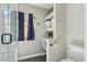 Clean bathroom with glass shower enclosure, blue accents, and small desk nook with storage shelves at 438 E Larkspur Ln, Tempe, AZ 85288