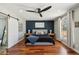 This stylish bedroom features a dark accent wall, wood floors, and a large window with great natural light at 438 E Larkspur Ln, Tempe, AZ 85288