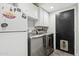 This spacious laundry area boasts stainless steel appliances and ample storage with overhead white cabinetry at 438 E Larkspur Ln, Tempe, AZ 85288
