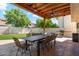 Relaxing covered patio with ceiling fan, large table, chairs, BBQ and well-kept lawn at 438 E Larkspur Ln, Tempe, AZ 85288
