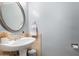The powder room showcases an oval mirror and pedestal sink with beige tile accents at 4600 N 68Th St # 379, Scottsdale, AZ 85251