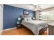 A well-lit bedroom boasts a striking blue accent wall, a ceiling fan, and wood floors at 4600 N 68Th St # 379, Scottsdale, AZ 85251